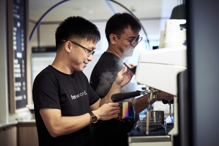 2 men in front of a coffee machine