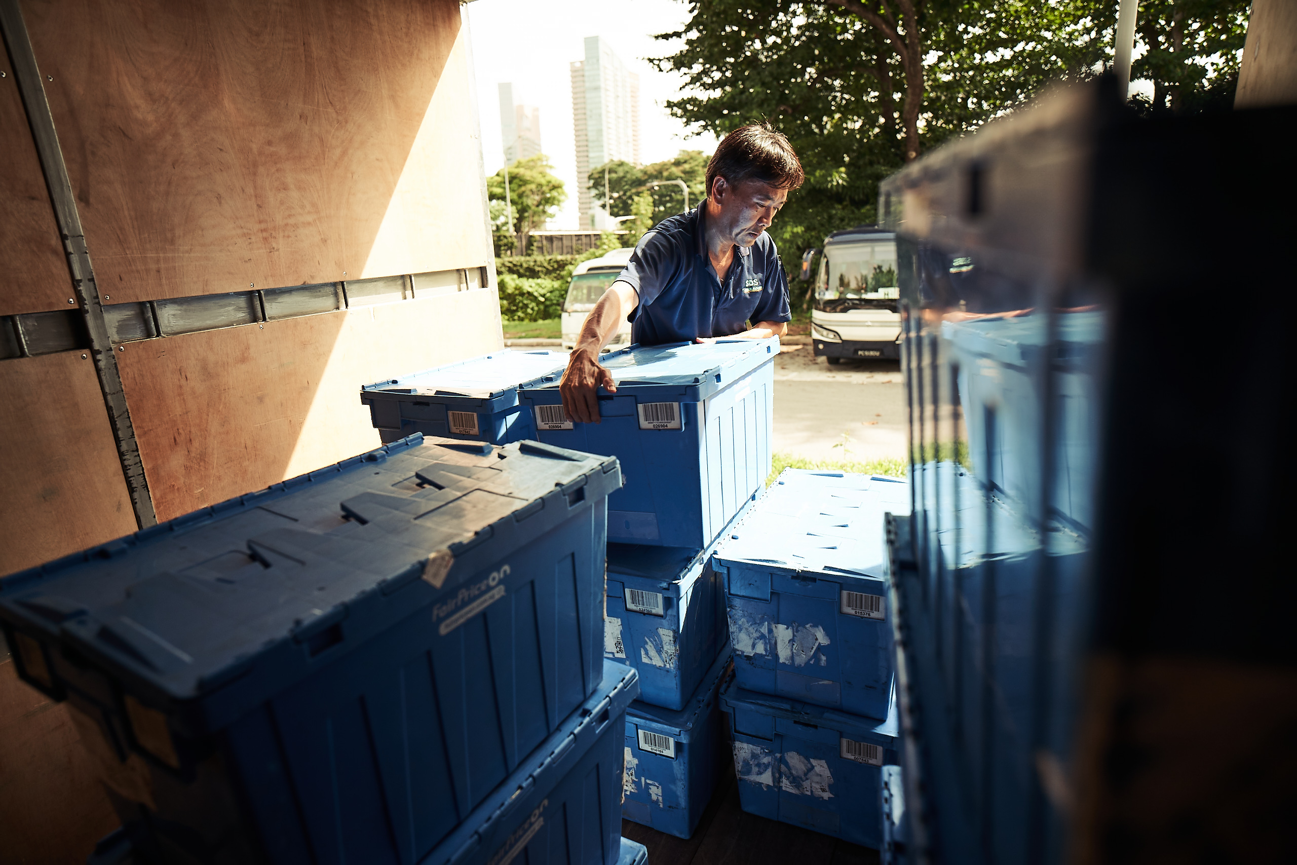 A man is lifting a box from the back of the truck